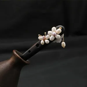 Detailed view of handmade ebony wood hair stick with delicate natural pearl flowers
