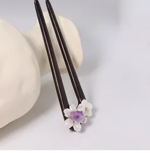 Gros plan d'une épingle à cheveux en ébène avec cristal violet et fleur de perle
