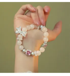 Close-up view of an elegant pink crystal beaded bracelet with a silver bow charm