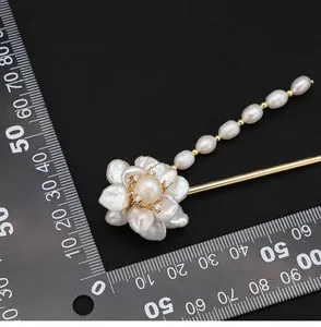 Detailed view of baroque pearl flower hair stick next to measuring scale