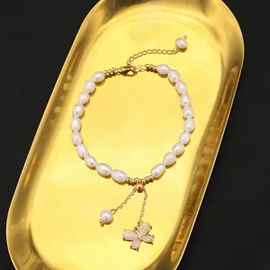Vista dettagliata del bracciale di perle d'acqua dolce con ciondolo a farfalla e grani d'oro