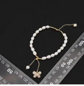 Dettaglio del bracciale di perle d'acqua dolce con ciondolo a farfalla e righello
