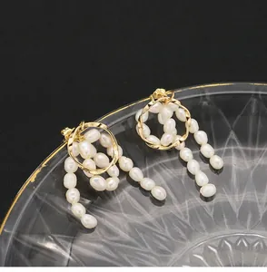 Detailansicht von Naturperlen-Ohrringen mit goldfarbenen gedrehten Metallringen