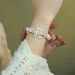 Elegant pink crystal beaded bracelet featuring a sparkling bow charm, worn on wrist