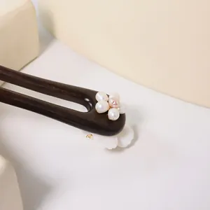 Elegante ebbenhouten haarspeld met verfijnde accenten van parel- en schelpenbloemen