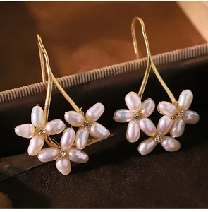 Close-up of elegant floral baroque pearl earrings with gold finish on jewelry box