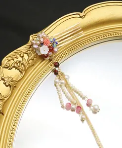 Detail view of Chinese style hair comb with pearls, cloisonne butterfly, and tassels