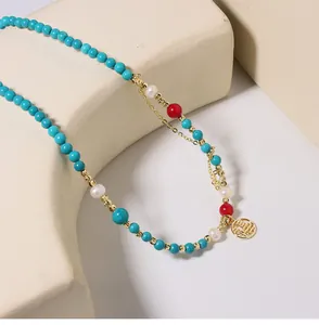 Nahaufnahme einer ethnischen Kette mit Türkisperlen, Süßwasserperlen und einem Gold-Fu-Anhänger