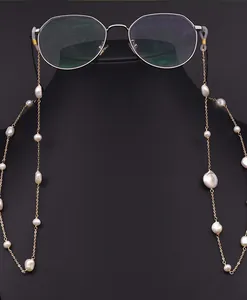 Detailed view of a natural baroque pearl glasses chain displayed on a black neck bust