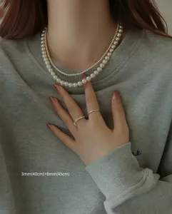 Close-up detail of 3mm and 8mm double-strand pearl necklace shown on a model neck
