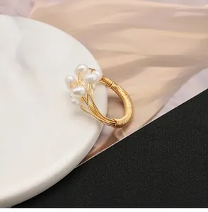 Detaillierte Nahaufnahme eines golddrahtumwickelten Rings mit echten Süßwasserperlen