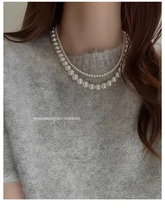 Detailed macro view of a double-layered pearl necklace featuring 4mm and 10mm white pearls