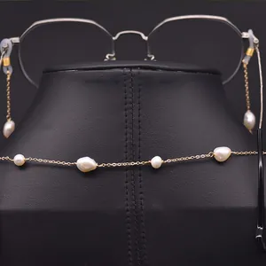 Detailed close-up of natural baroque pearl glasses chain with gold-plated link chain