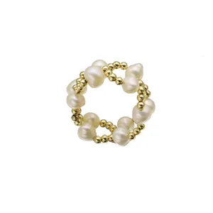Squisito anello di perle naturali fatto a mano con eleganti perline d'oro su sfondo bianco