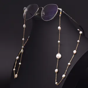 Elegant gold glasses chain with Baroque pearls displayed on a black mannequin head.