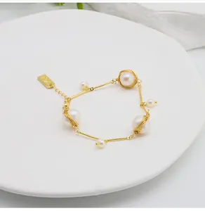 Detailed shot of handmade 18k gold filled wire wrapped bracelet with freshwater pearls.