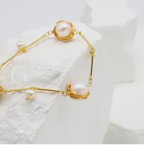 Macro view of 18k gold-filled wire-wrapped bracelet featuring natural freshwater pearls.