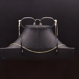 Élégante chaîne de lunettes en perles d'eau douce dorées sur buste d'exposition noir