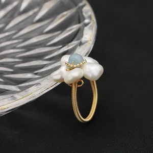 Detailed view of handcrafted natural pearl and aquamarine floral wire-wrapped open ring.