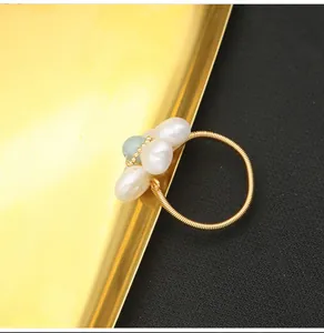 Detailed macro shot of handmade wire-wrapped gold ring with natural pearl flower design