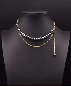 Detailed view of a multi-layered necklace featuring dark baroque pearls and a gold chain