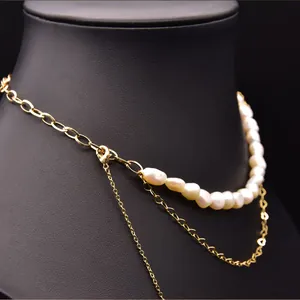 Macro detail of natural baroque pearl necklace with layered vintage gold chains