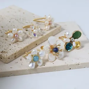 Elegant handmade natural pearl floral wire-wrapped adjustable rings shown on stone slabs