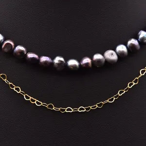 Elegant double-layered necklace featuring peacock baroque pearls and gold heart links