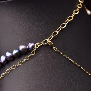 Detail of multi-layer natural baroque pearl necklace with golden chains