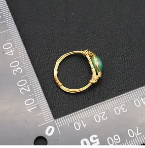 Detailed view of wire-wrapped jade ring on a measurement scale for size reference