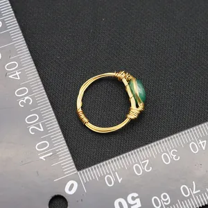 Vintage gold wire-wrapped ring with a green jade stone displayed next to a ruler