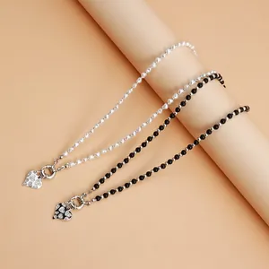 Close-up view of trendy black and white beaded necklaces with rhinestone heart pendants