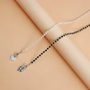 Close-up of stylish beaded necklaces with rhinestone heart pendants and spring clasps.