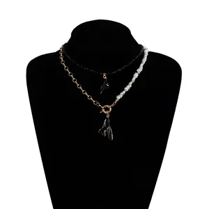 Vue détaillée d'un collier à deux rangs avec des pendentifs noirs et des perles baroques