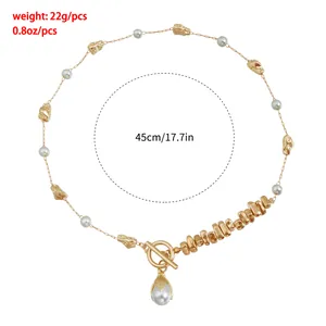Close-up detail view of gold-tone alloy necklace with irregular metal and pearl accents