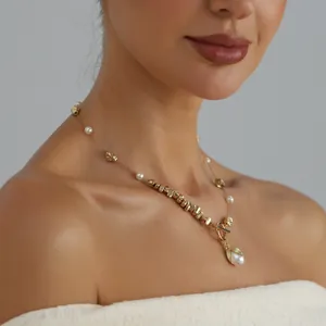 Detailed view of irregular gold metal beads and pearl spliced necklace worn by model