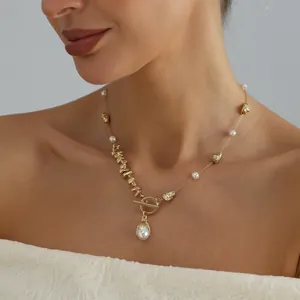 Detail shot of irregular gold metal and pearl spliced necklace with toggle clasp