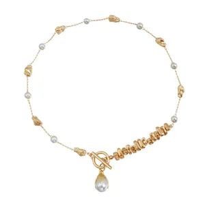Elegant gold necklace with irregular metallic beads and pearls, features a toggle clasp.