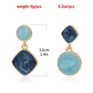 Close-up of mismatched blue marbled enamel geometric drop earrings with dimensions