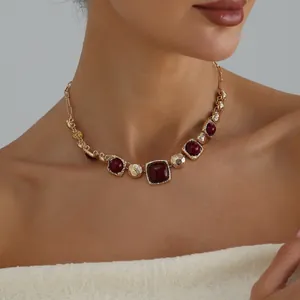 Elegant vintage gold necklace with square burgundy stones on a female model