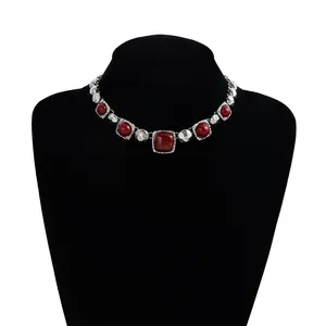 Vintage silver-tone necklace featuring red geometric resin stones on black display bust