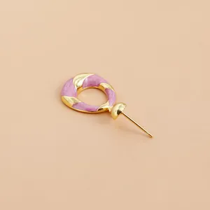 Close-up showing the pink enamel texture and gold twisted metal of the earring