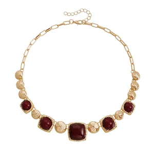 Vintage gold-toned chunky necklace featuring red square stones and textured spheres.