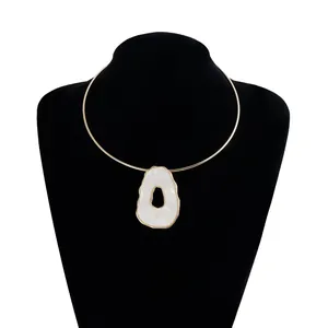 Macro view of vintage gold choker necklace with irregular white resin pendant detail