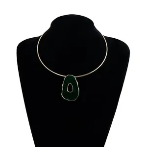 Close-up detail of a vintage gold choker with an irregular green hollow pendant.