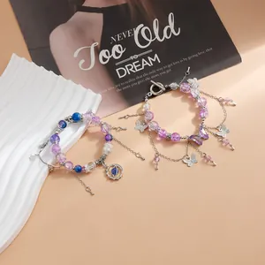 Vue détaillée de bracelets perlés violets avec des breloques papillon et planète.