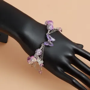 Détail du bracelet breloque papillon violet avec des perles sur un mannequin noir