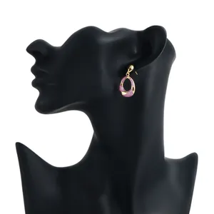 Elegant pink enamel and gold geometric earrings displayed on a professional black mannequin bust