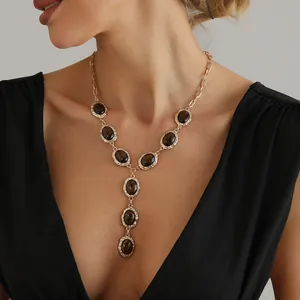 Dettaglio di un'elegante collana a Y con pietre occhio di tigre su una modella
