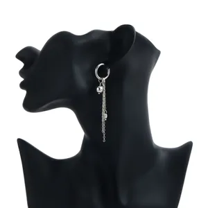 Detail shot of silver dangle hoop earring featuring bead and long chains on mannequin